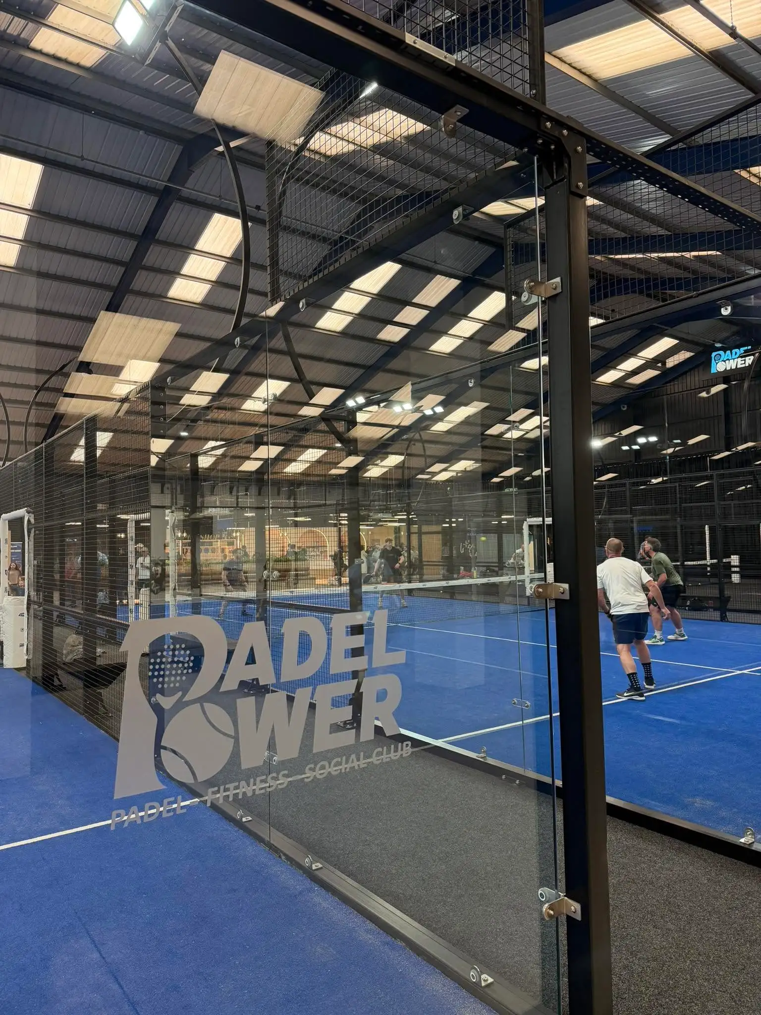 Gracze na krytym korcie do padla w klubie korzystającym z Padel Fast
